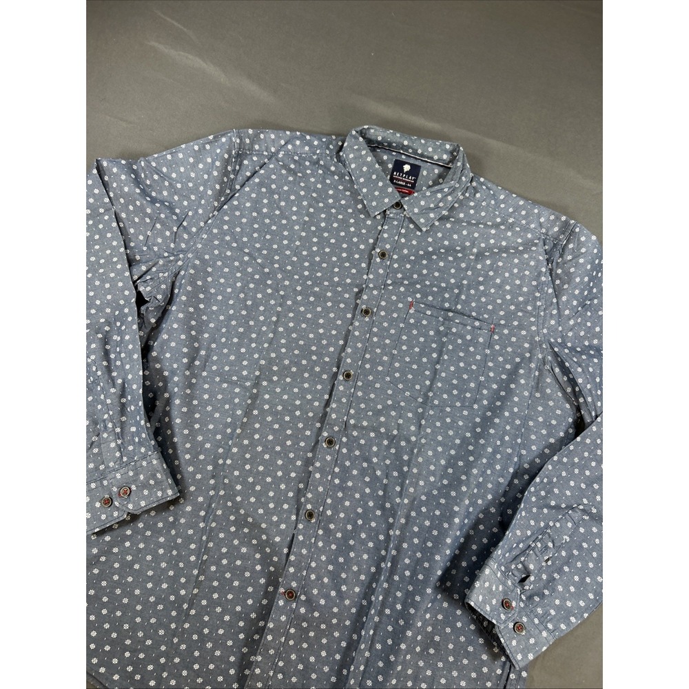 blue long-sleeve button-up shirt featuring a small white geometric